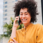 pretty-young-woman-with-curly-hair-yellow-shirt-calling-using-smart-phone-hispanic-smiling-girl-talking-by-cellphone-with-happy-face-communication-concept_639864-242